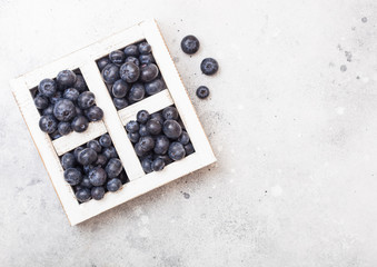 Fresh raw organic blueberries in vintage wooden box on stone kitchen background. Space for text. Top view