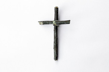 Cross made from tree branch isolated on white background