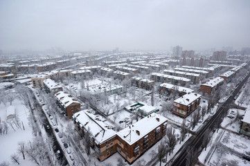 The aerial View of residential district in dusky winter day.View over city rooftops with sunlight and snow.Moderns buildings at Industrial uptown, residential neighbourhood/Beautiful winter cityscape