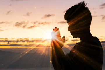 Silhouette of christian man hand praying,spirituality and religion,man praying to god. Christianity...