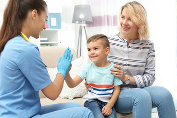 Children's doctor visiting little boy at home