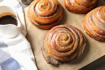 Cinnamon rolls and jug with chocolate syrup on table