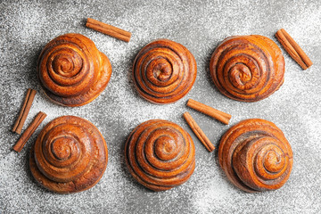 Flat lay composition with freshly baked cinnamon rolls on grey background