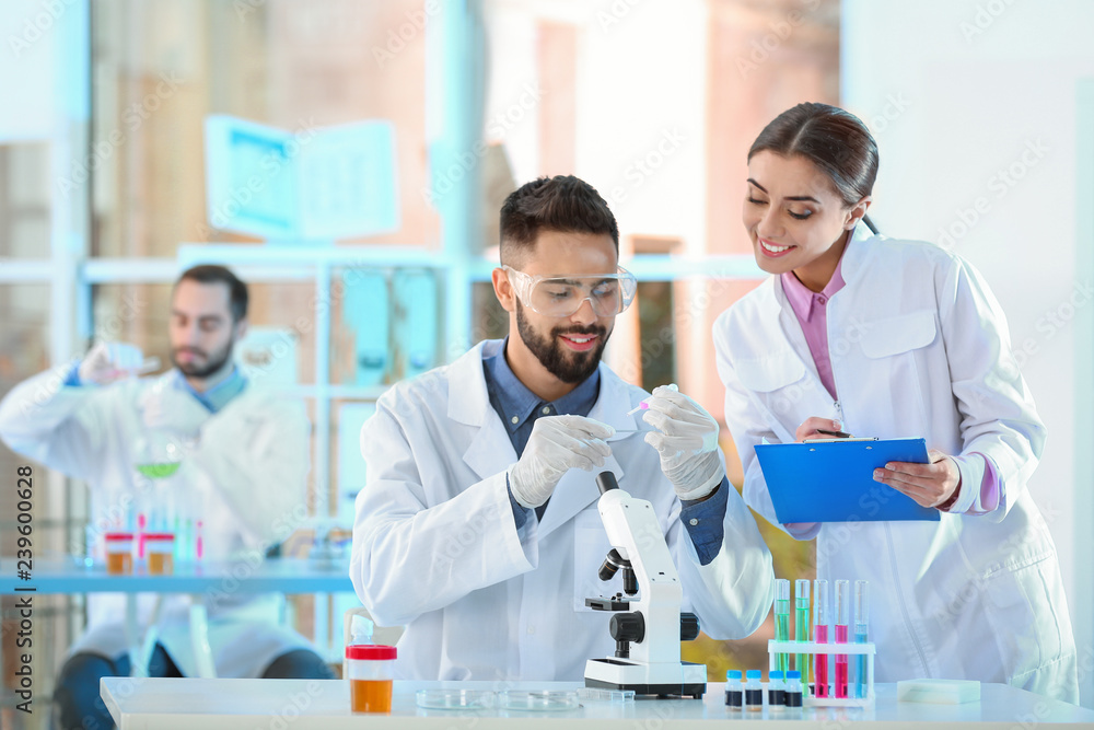 Wall mural young scientists working in laboratory. chemical analysis