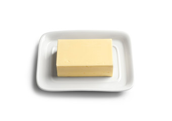 Ceramic dish with block of fresh butter on white background