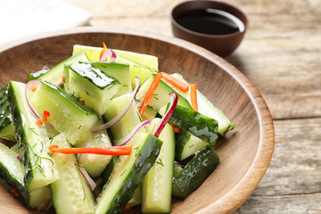 Plate with delicious cucumber salad on table, closeup