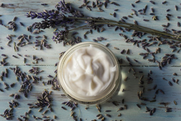 Homemade facial cream of lavender on a light wooden background