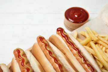 Poster Hot dogs, french fries and sauce on table, closeup © New Africa