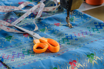 The measuring cord and scissors on fabric with sewing machine