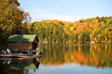 Fototapeta na wymiar Boat House and Dock on a Beautiful Lake with Colors of Autumn