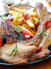 Barbecue tomahawk pork steak with salad  and french fries  on a plate