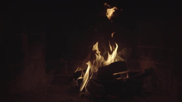 Flames dance over split logs. Video 4k UHD with sound