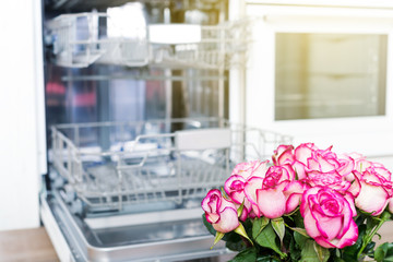 Dishwasher and beautiful bouquet of flowers in kitchen interior, no people