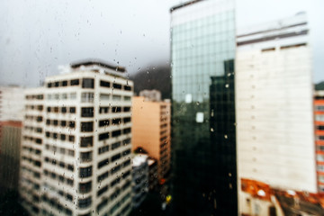 Obraz premium Macro of rain drops on a window with buildings in the background in the Copacabana neighborhood (Rio de Janeiro)