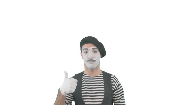 Happy mime showing thumbs up. Cheerful behavior and broad smile of a male actor during the pantomime show. Isolated on white background.