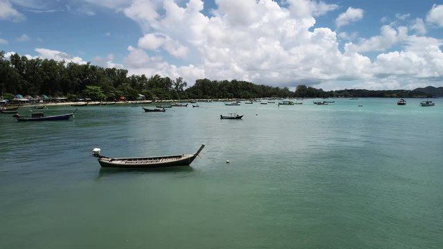 Longtail fishing boats in tropical andaman sea at rawai beach phuket Thailand,4K footage Drone flying shot