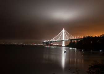 bay bridge at night reflecting on low clouds