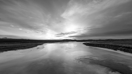 Black and white sunset reflected over ice