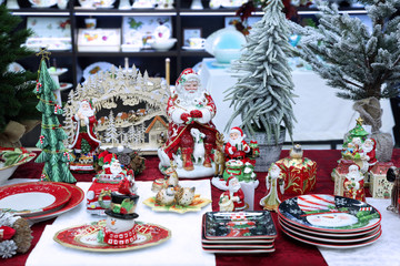 Colorful Christmas Souvenirs, decorative statues of Santa Claus, snowman, plates with symbols of the new year