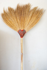 broom or broom head to sweeping the dust or cleaning floor on white plain wall.