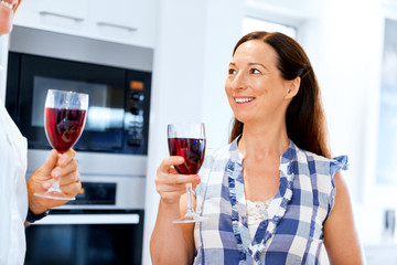 Senior woman with holding a glass of wine indoors