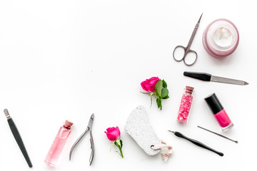 Naklejka premium manicure equipment with nail polish and rose petals white background top view space for text