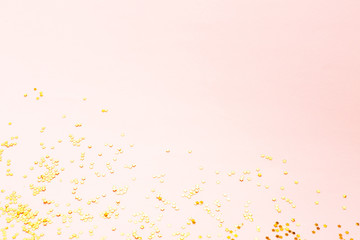 Gold color confetti on pink