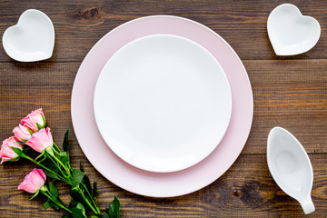Empty pink colorful plate with flower for table setting on wooden table backgroung top view copy space
