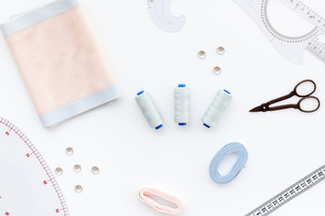 Woman hobby. Set for tailor shop with thread, scissors, fabric on white background top view