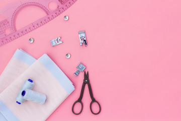Tailor shop with thread, scissors, fabric. Sewing as hobby. Pink background top view mockup
