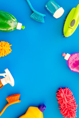 Housecleaning with detergents, soap, cleaners and brush in plastic bottles on blue background top view mockup