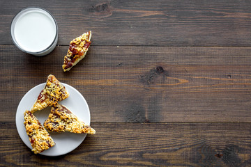 Children tradition evening dessert. Milk and homemade cookies on dark wooden background top view space for text