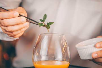 Barman decorating  cocktail at a nightclub. Nightlife and entertainment concept