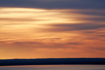 Naklejka na ściany i meble Sunrise clouds over lake abstract