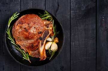 Grilled piece of meat. Juicy beef steak in a cast-iron skillet with rosemary and garlic.