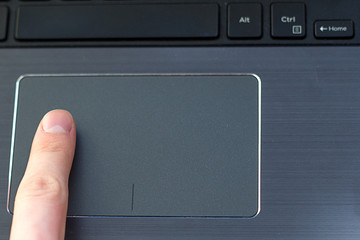 male index finger on a laptop trackpad