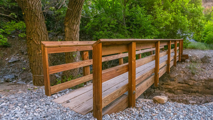 Hiking trail with wood bridge over a rocky stream