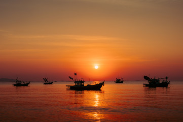 fishing boat at sunset on the beach.