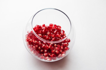 pomegranate seeds in a bowl isolated on white
