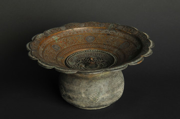 ancient metal bowl on dark background. antique bronze tableware