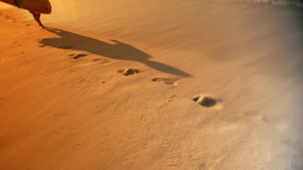 Surfer leaves footprints on the beach