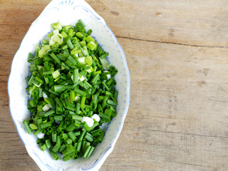fresh spring onion chopped green onions on wooden background