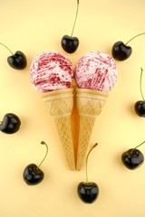Cherry Bath Bomb.Pink striped bombs for a bath in a waffle cup and ripe sweet cherry berries on  yellow background.Organic cosmetics with sweet cherry extract