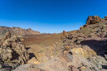 The lava fields of Las Canadas caldera of Teide volcano and rock formations - Roques de Garcia. Tenerife. Canary Islands. Spain.