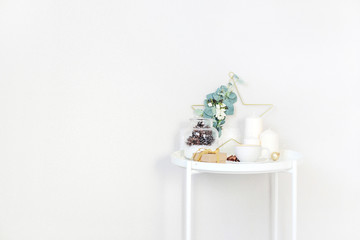 Christmas interior, Christmas decor on the table near the bed. Candles, wreath, gift box.