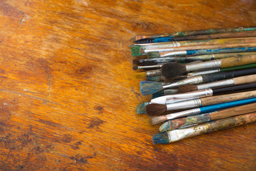 A set of artistic brushes on a wooden palette with empty space for text