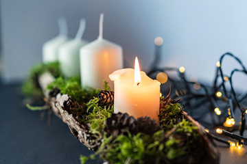 advent christmas wreath with 4 candels and the first candel burning