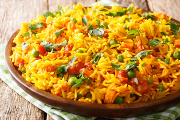 Vegetarian Indian rice with vegetables close-up on a plate. horizontal, rustic style