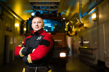 Photo of young firefighter on background of fire truck