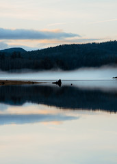 Obraz na płótnie Canvas foggy sunset on the lake 